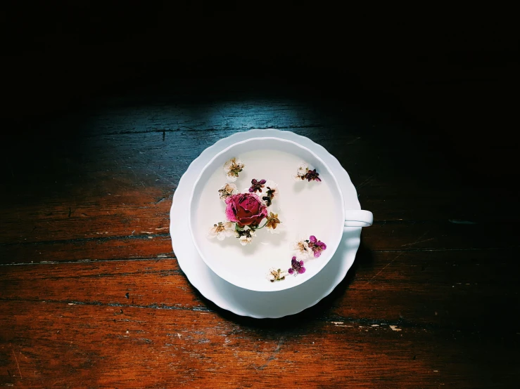 a bowl with a flower on it is shown in the center of the plate