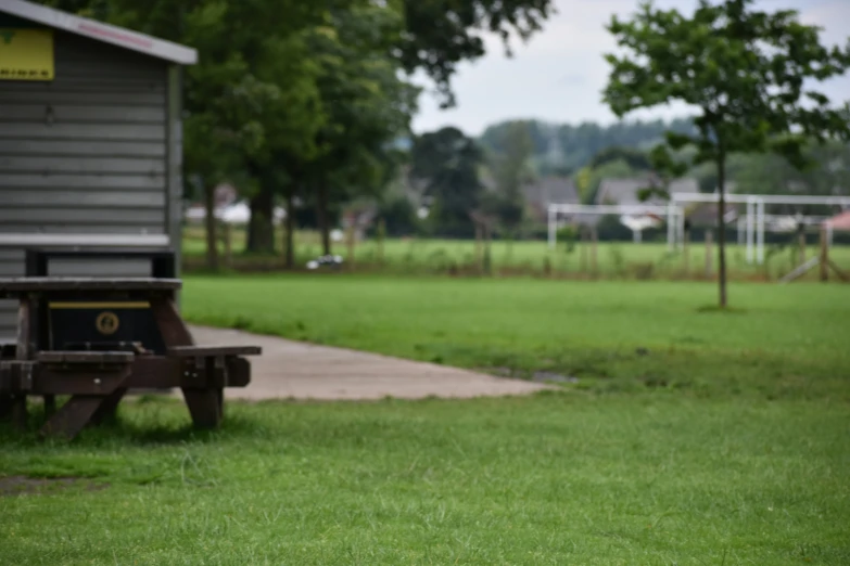 a picnic table and picnic chair in front of the soccer field