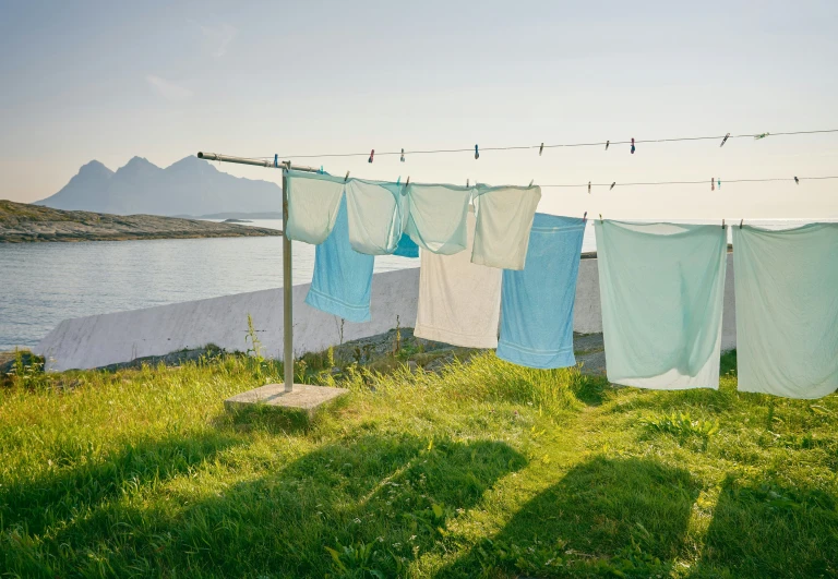 clothes hanging on a rope next to some water