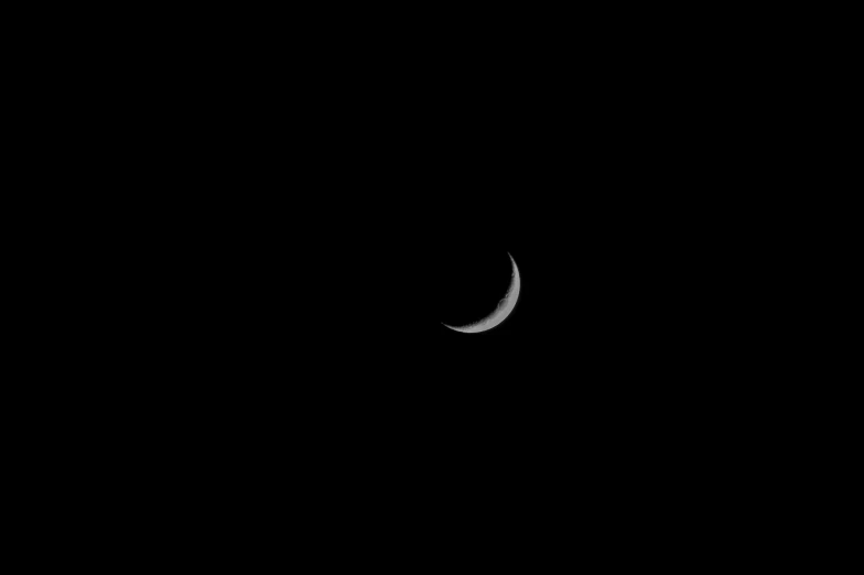 a crescented moon in the dark sky with an earth background