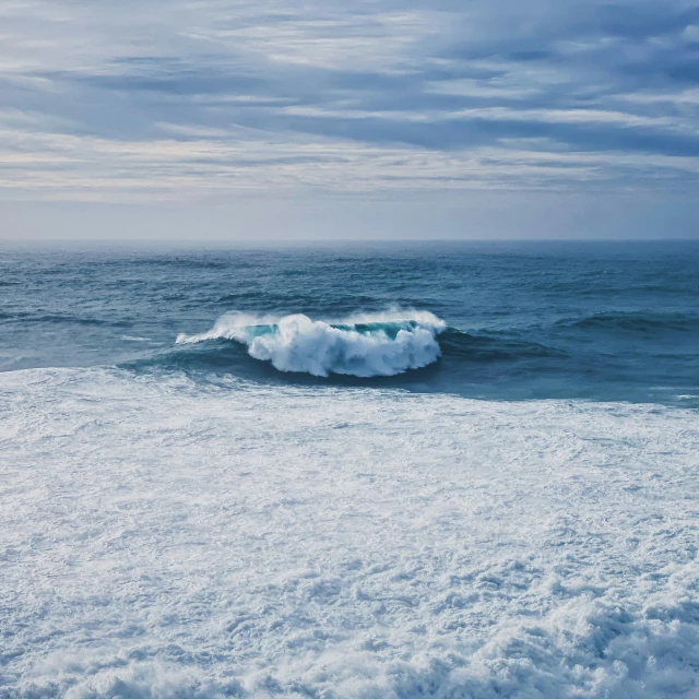 a big white wave coming in to the shore