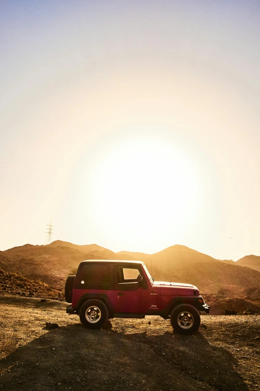 a red truck driving down the road next to mountains