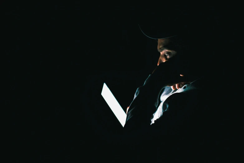 a man is using a laptop computer in the dark