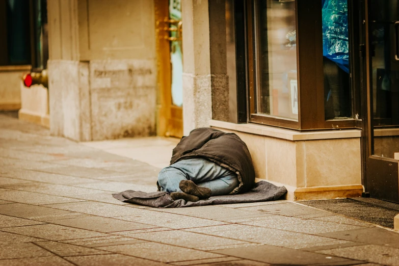 a person laying on the sidewalk in front of an office building