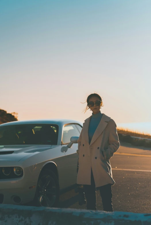 a woman standing next to a parked car