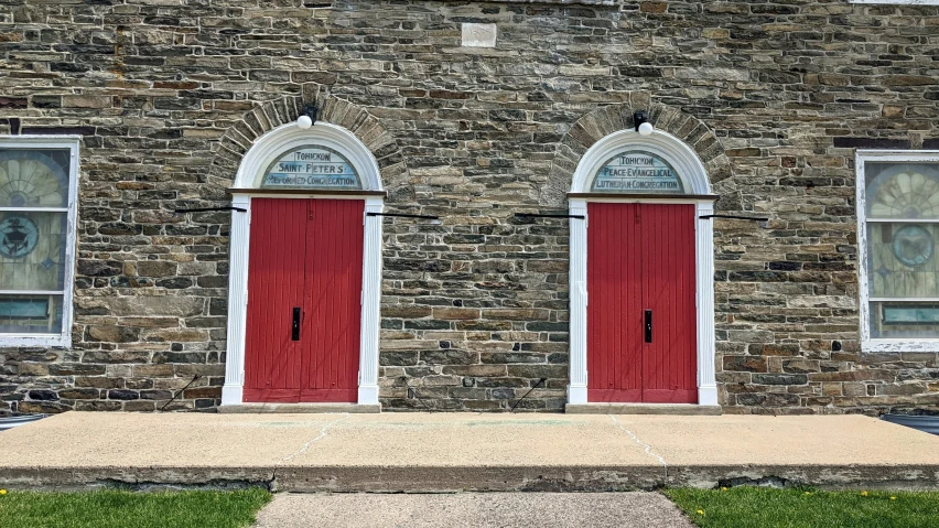 an old brick house has two red doors