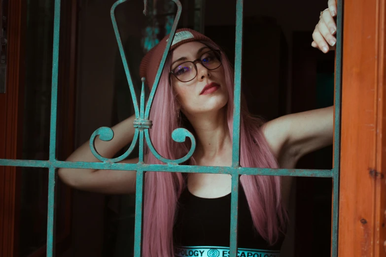 a person that has long pink hair looking through a window