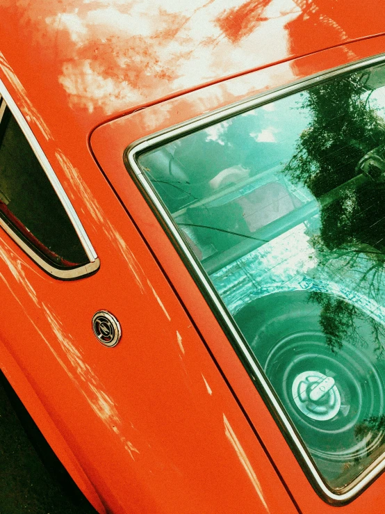 a small orange car parked near other vehicles