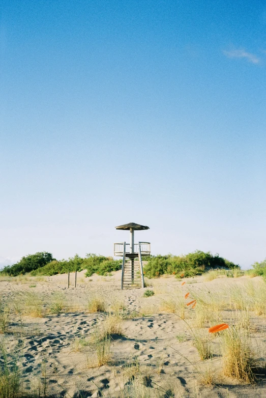 there is a white life guard tower in the grass