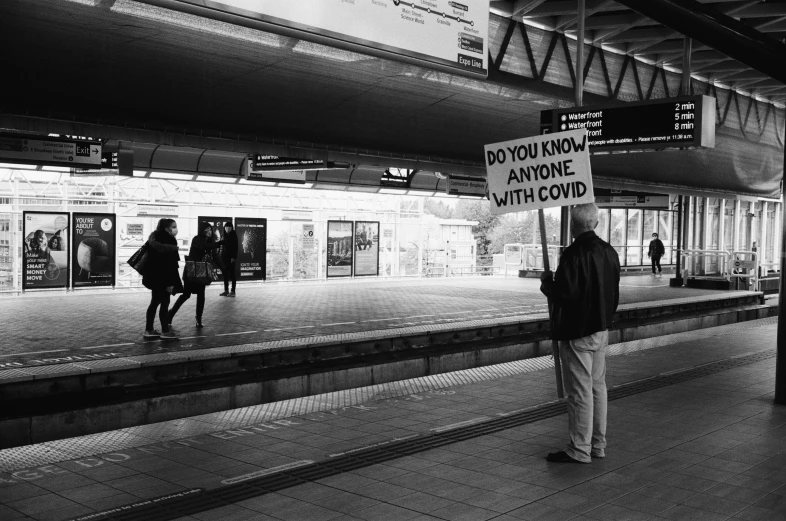 a man standing on a platform holding a sign