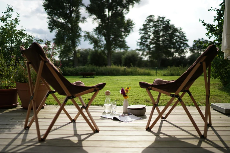 two wooden chairs facing each other near flowers