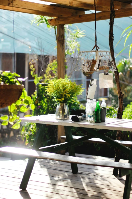 a table and bench with bottles and flowers