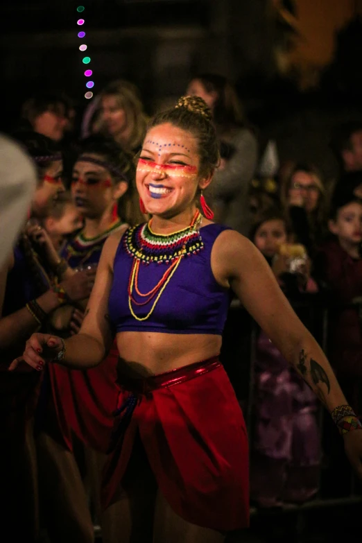 a person with face paint performing with a crowd