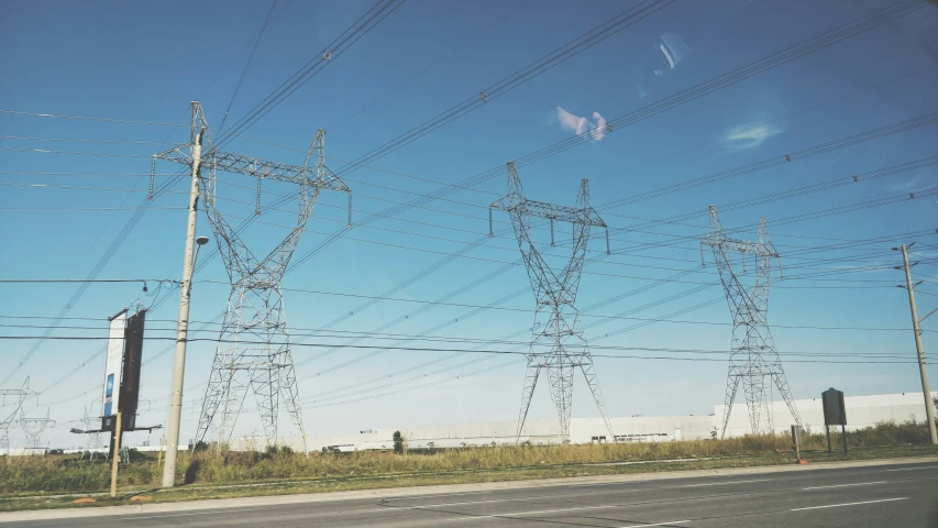 electric power lines line the roadway on a sunny day