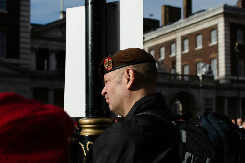 the man in the hat is by a pole