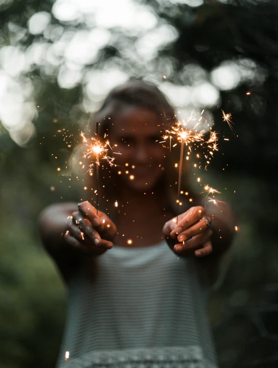 a beautiful woman holding sparklers in her hands