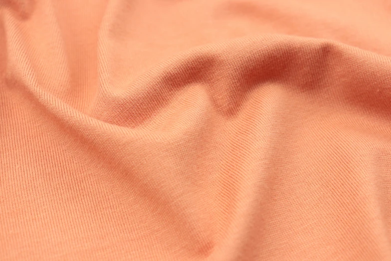 a closeup s of orange colored stretchy t - shirt fabric