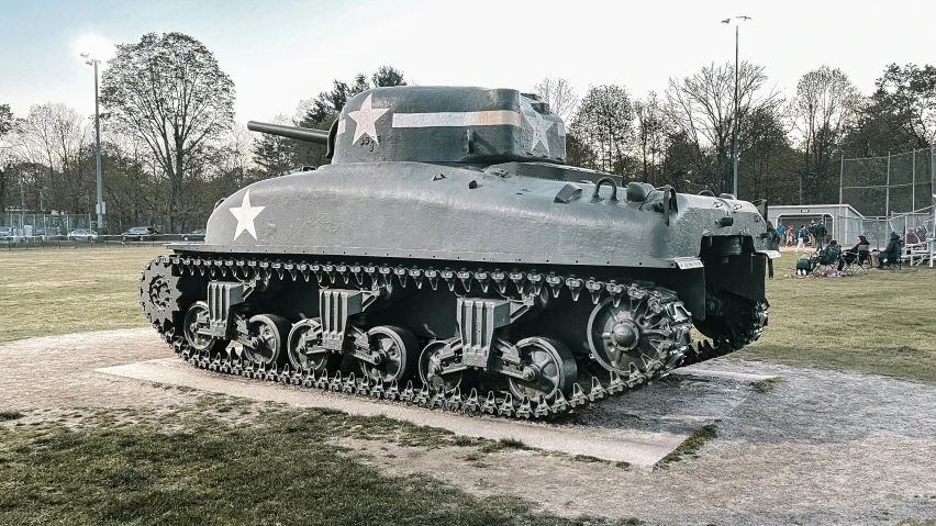 an old world war ii tank sits parked at the base of a grassy area