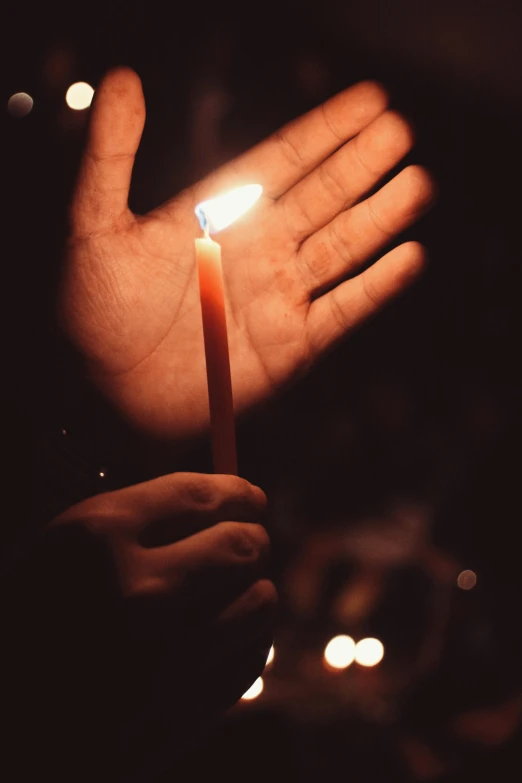 a person holding a candle in their hands