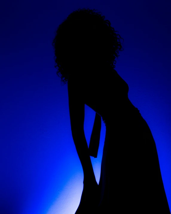 the silhouette of a girl in a black dress