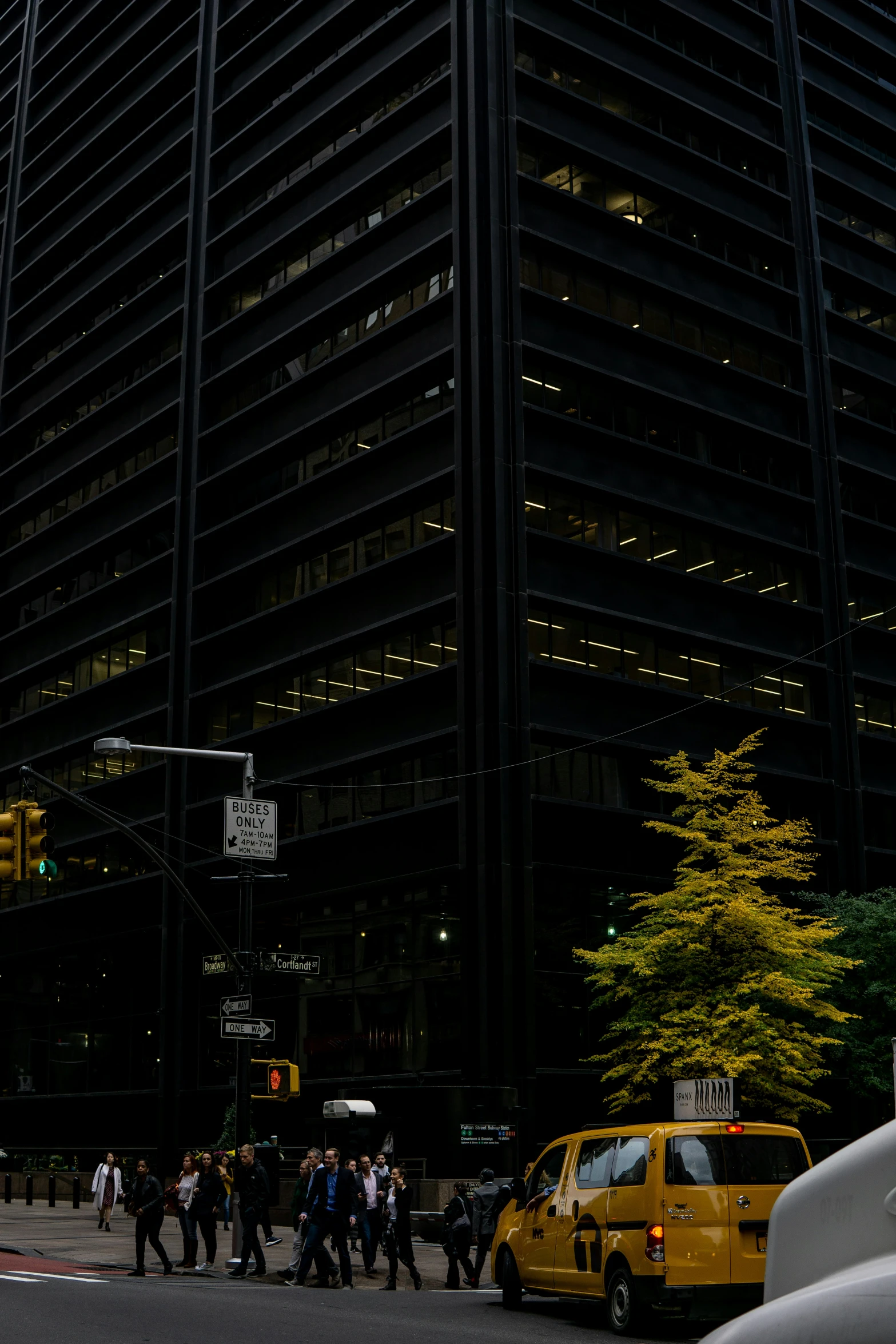 pedestrians walk along a street near a big building