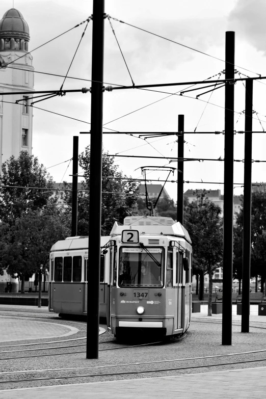 a trolley traveling down a street near some power lines