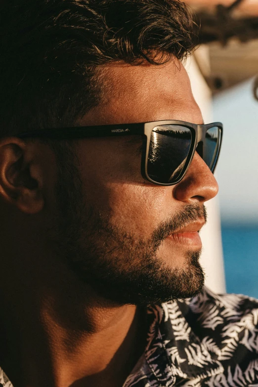 a man in a patterned shirt looking off into the distance