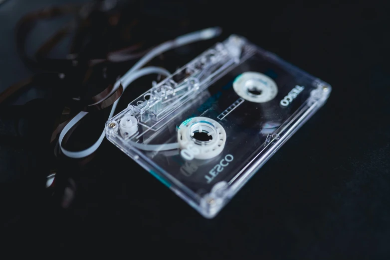 a cassette and a pair of scissors on top of a black table