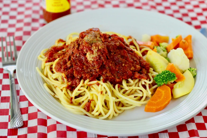 a plate of pasta, sliced fruit, and sauce