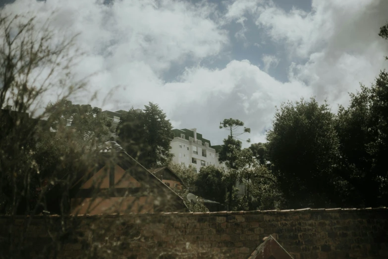 the view through a window shows the houses on a hill