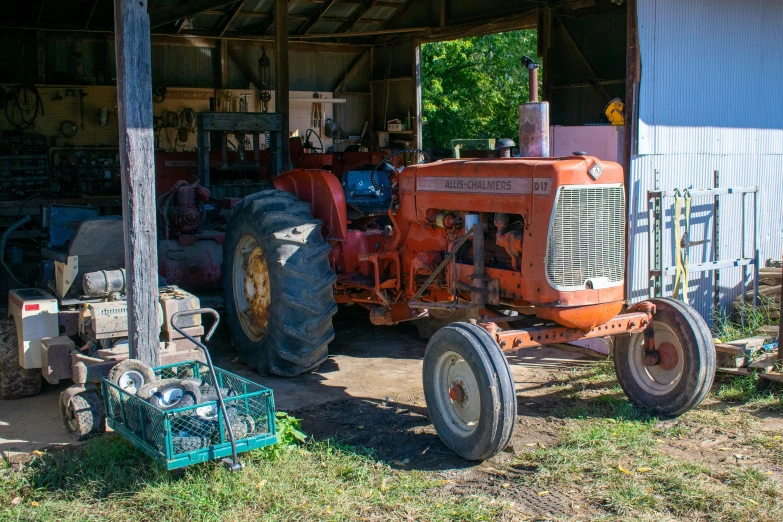 an old red tractor sitting inside a garage