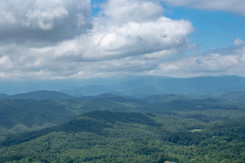 mountains with lots of trees and cloudy skies