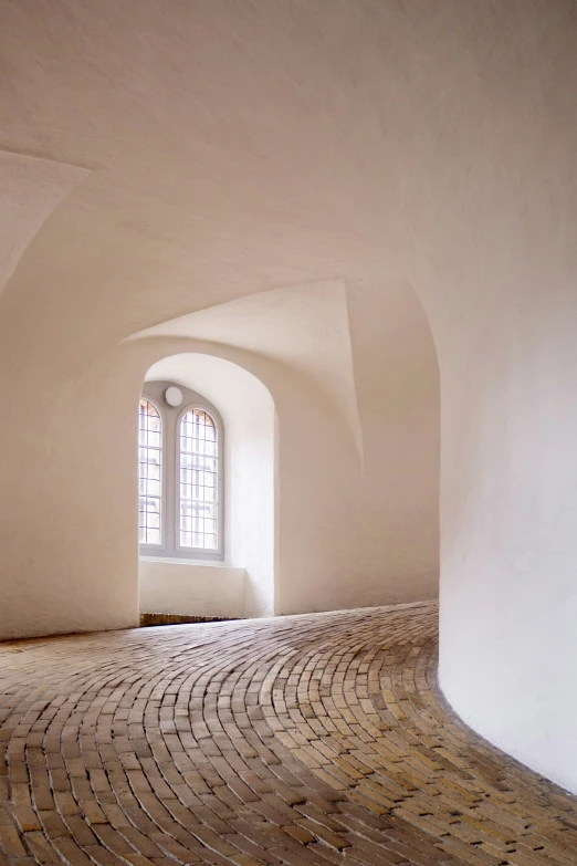 the room has an arch - window with white walls