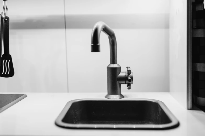 a kitchen sink and  board hanging in the back wall