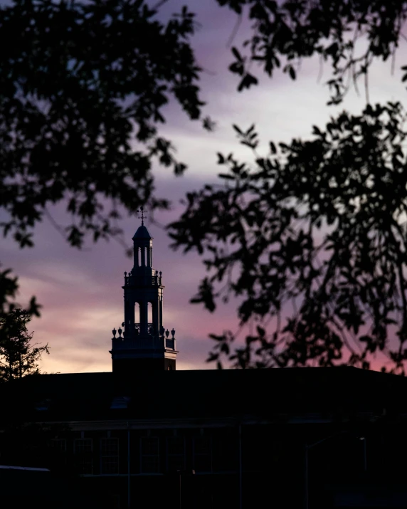 a view of a church steeple under a sunset