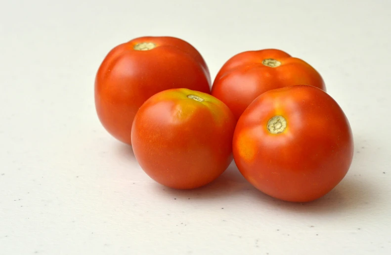 four pieces of ripe tomatoes are displayed on the table