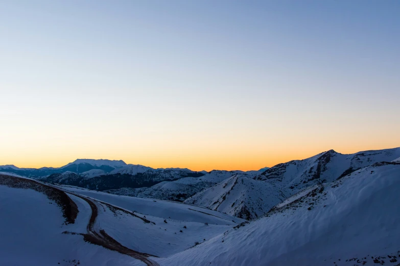 the view looking down on a road near mountains