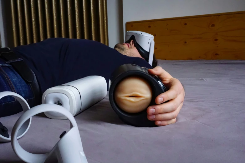 a man lays on his stomach while using a vacuum to vacuum down a bed