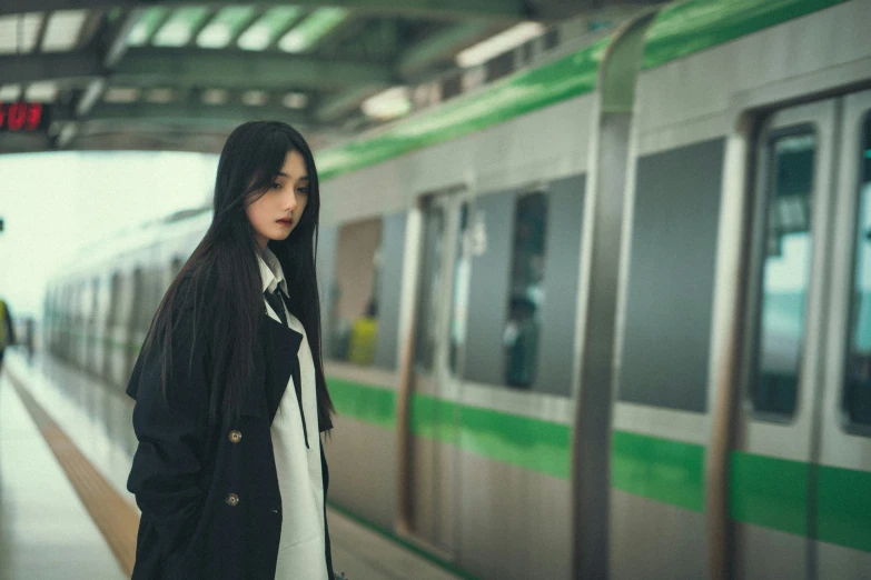 woman in hooded jacket waiting for a subway