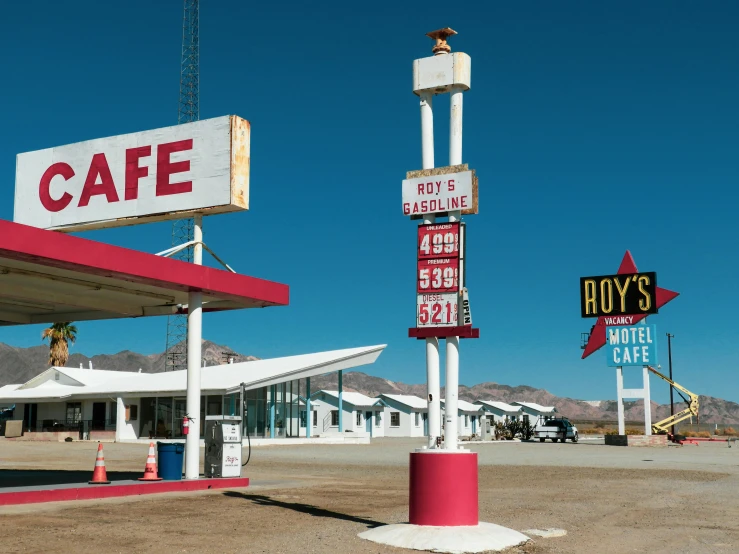 some colorful signs that are in the middle of a dirt lot