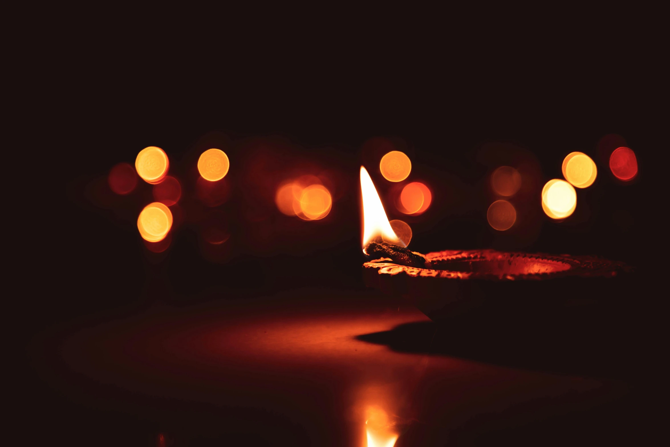 a lit candle with a background of blurry lights