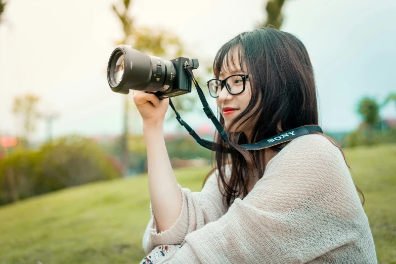 young woman holding up camera to take po