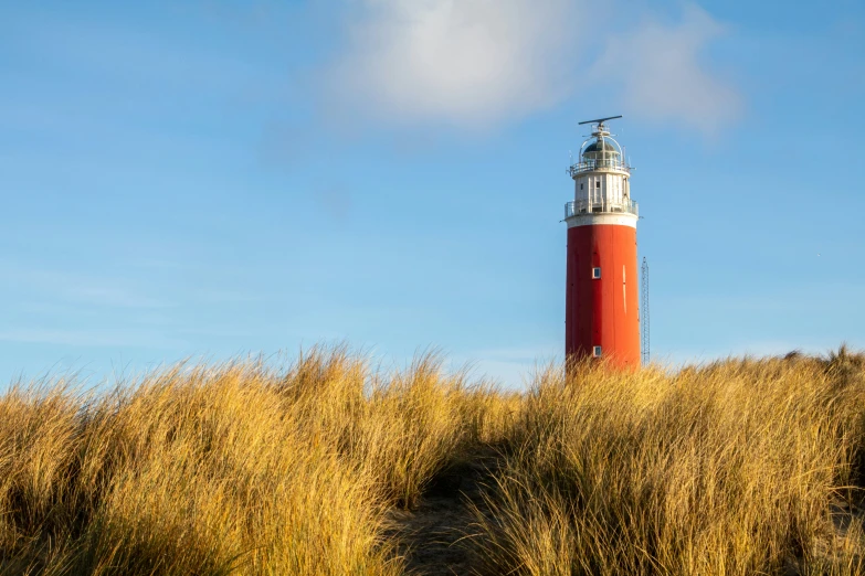 there is a red and white lighthouse on top of a hill