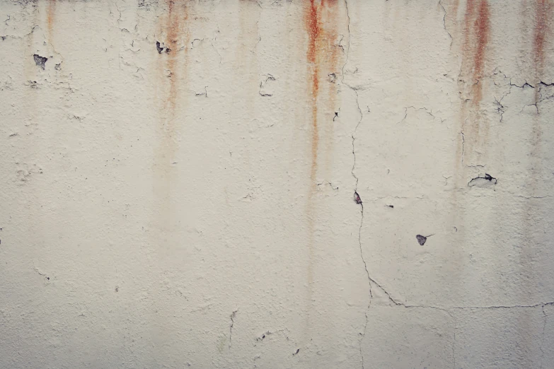 a white wall with rusted and weathered paint