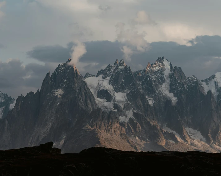 mountains that are covered in snow and surrounded by clouds