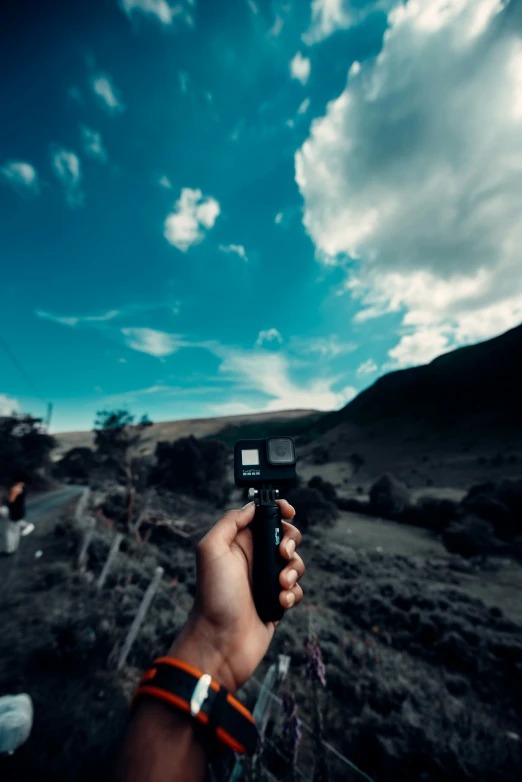 someone holding a camera with a sky background