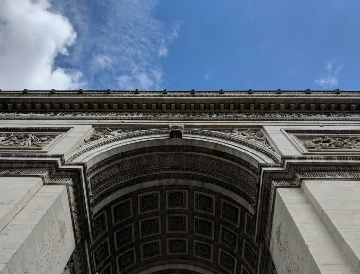 an arch with several windows below a blue sky