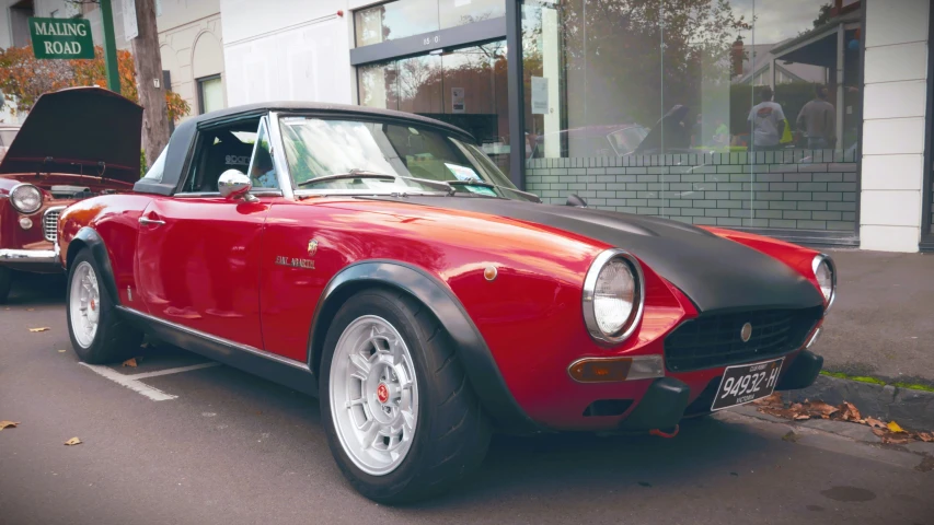 a classic car with a small engine parked in front of a building