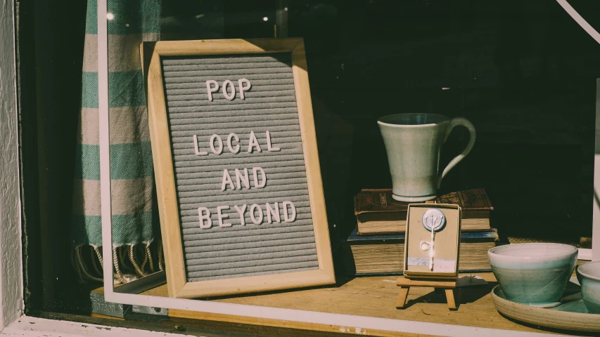 an old sign next to a cup and a teapot