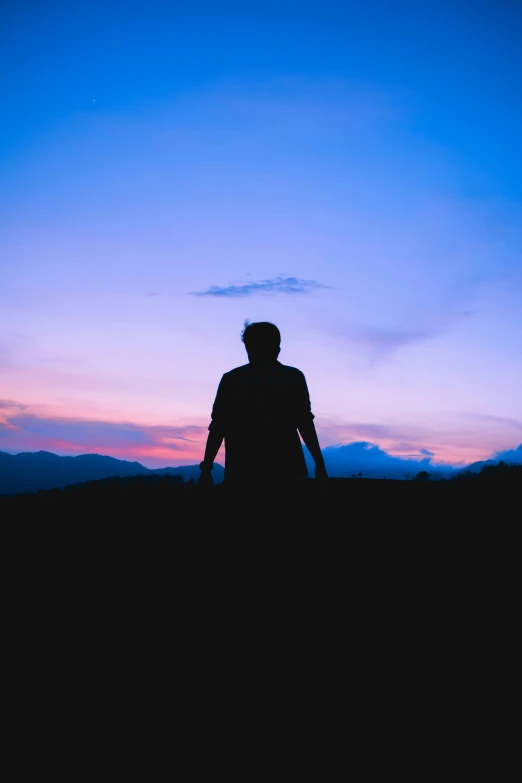 a man standing in the field at sunset